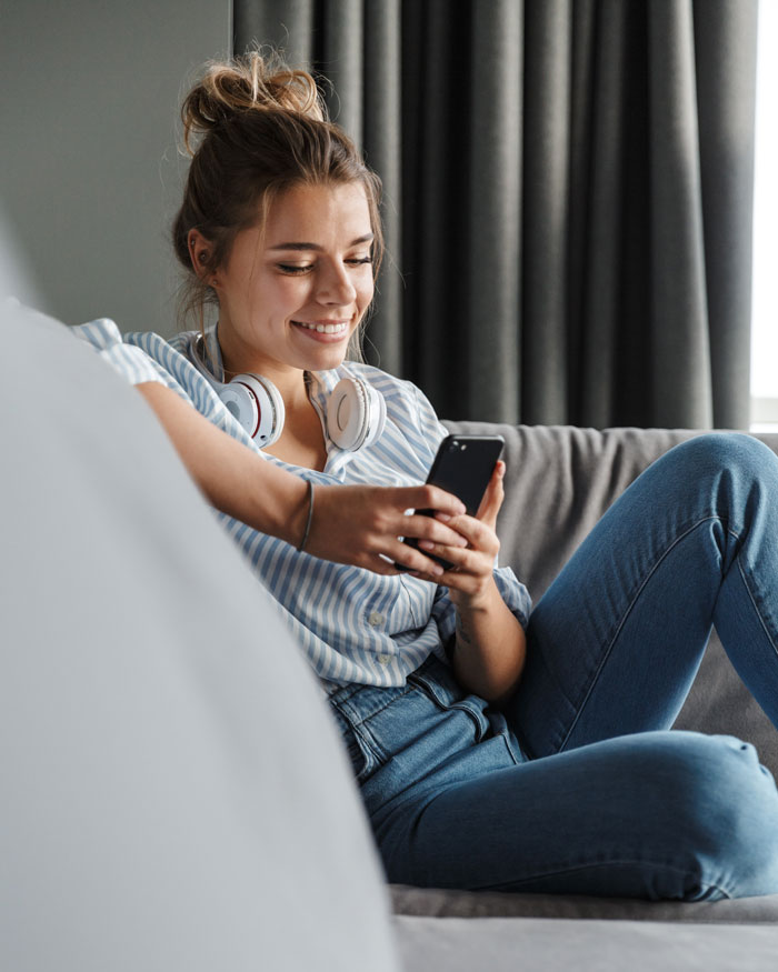 Woman On Couch Looking At Phone